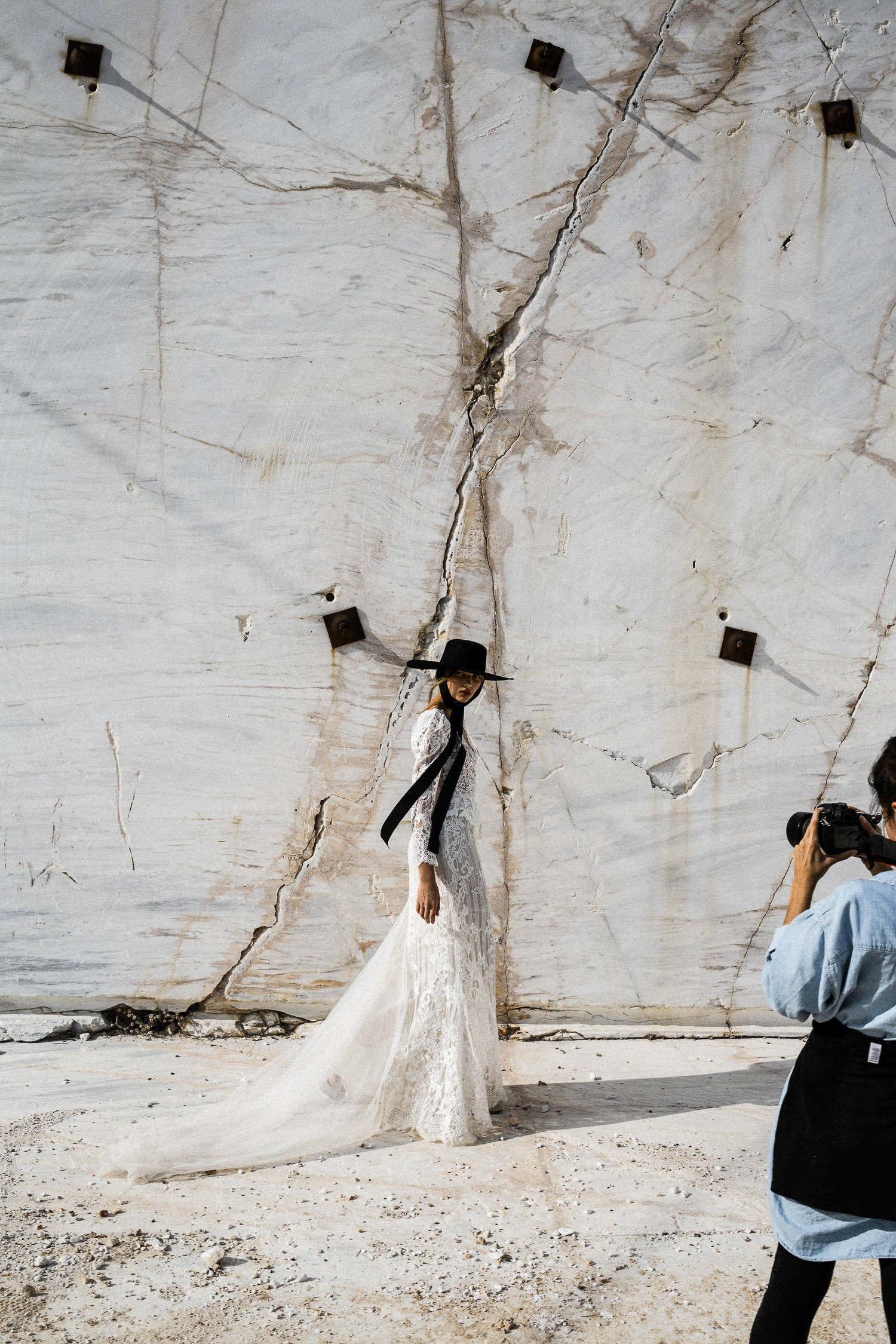 Bride walking at the barble quary witha black hat